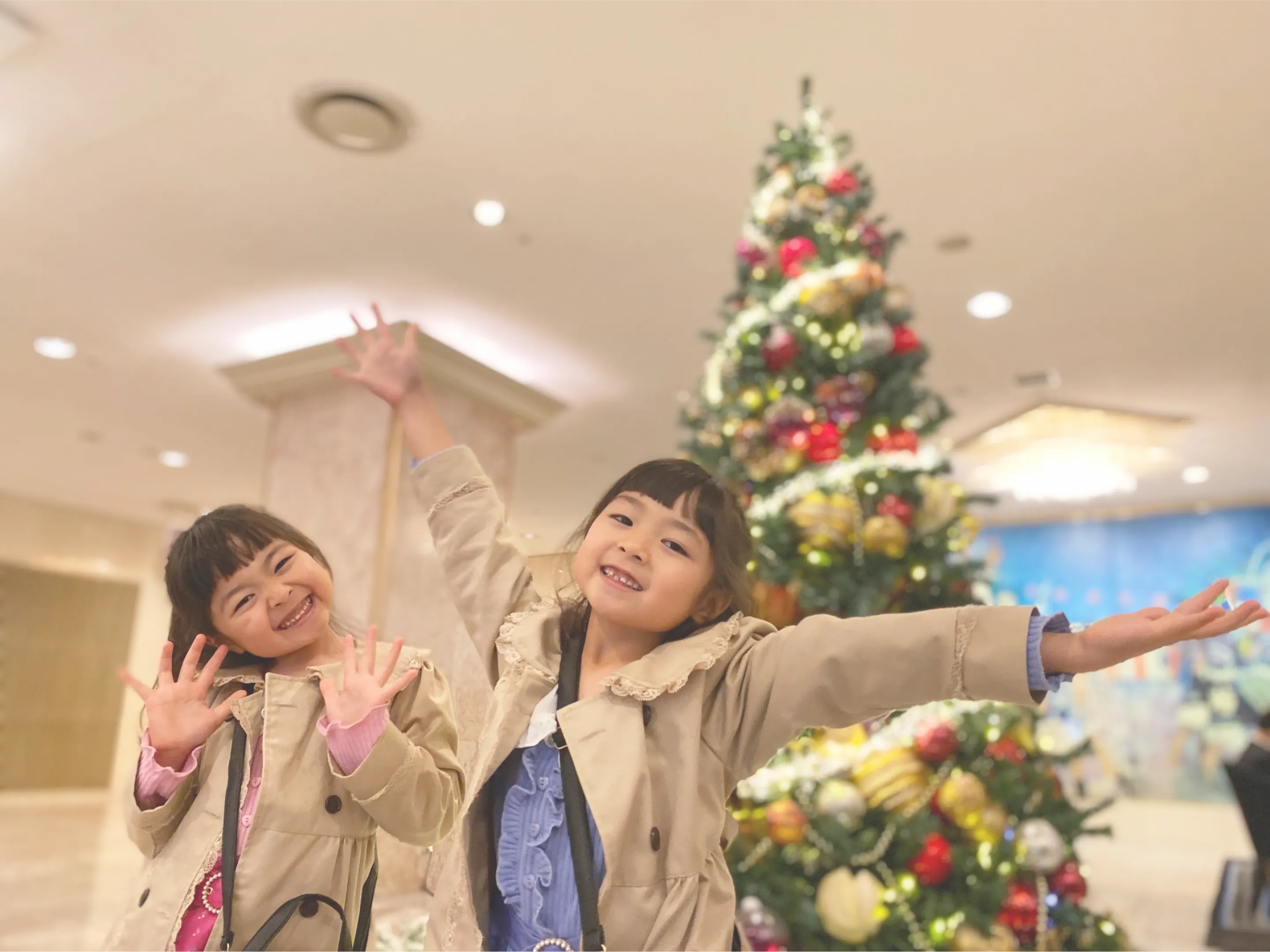 クリスマスツリーの前ではしゃぐ子供